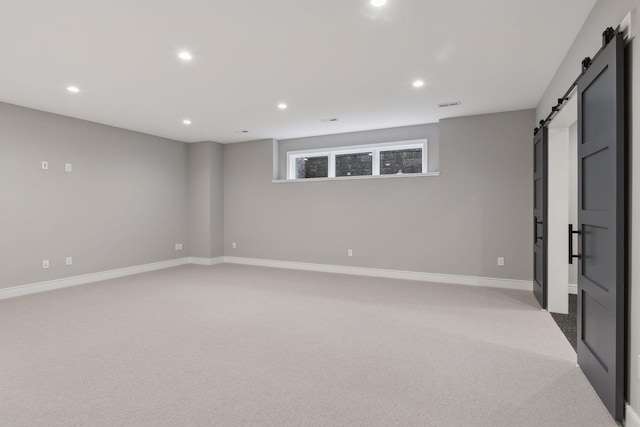 carpeted spare room featuring a barn door