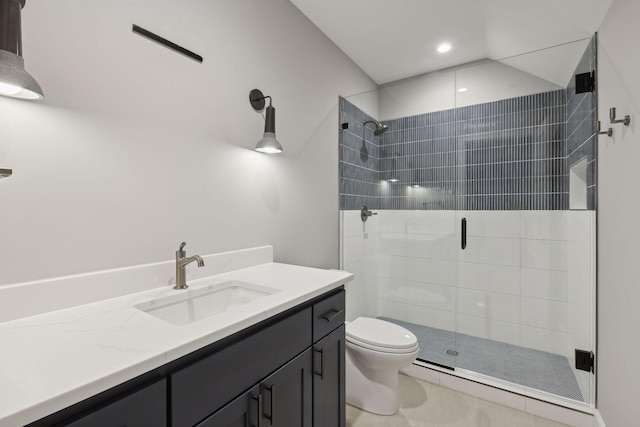 bathroom featuring vanity, a shower with shower door, and toilet