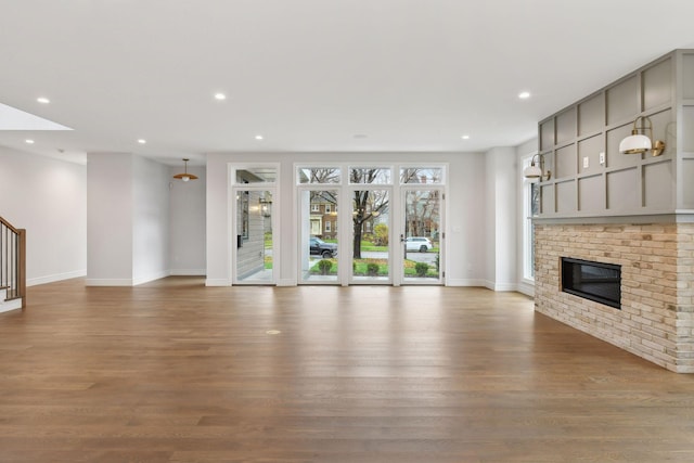 unfurnished living room featuring wood-type flooring and a fireplace