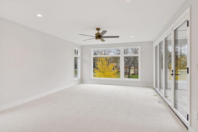 interior space featuring light carpet and ceiling fan