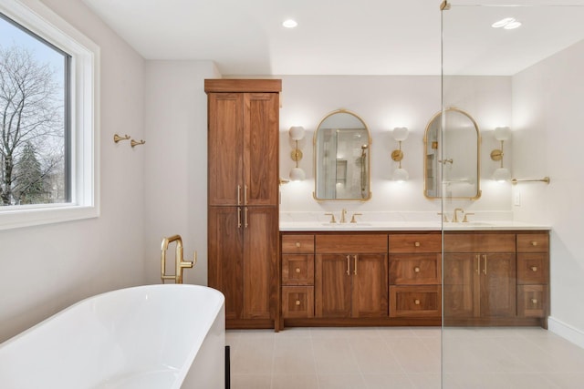 bathroom featuring vanity, a healthy amount of sunlight, and a bath