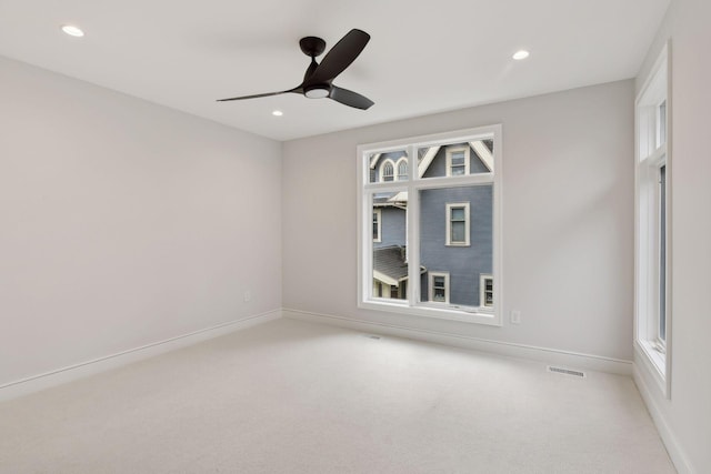 spare room with plenty of natural light, ceiling fan, and light carpet