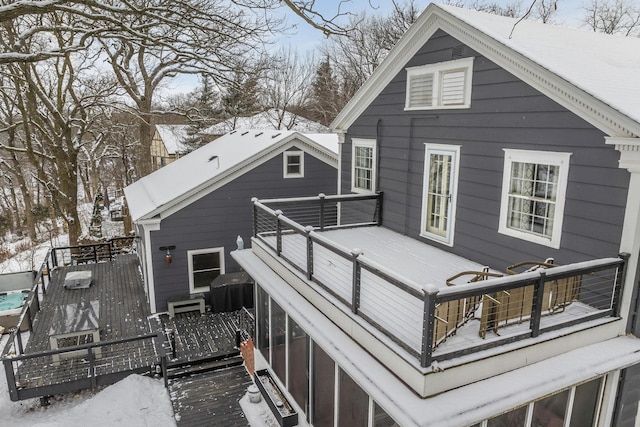 snow covered rear of property featuring a wooden deck