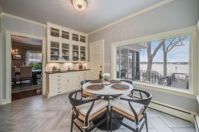 dining space featuring a baseboard radiator, ornamental molding, and a baseboard heating unit