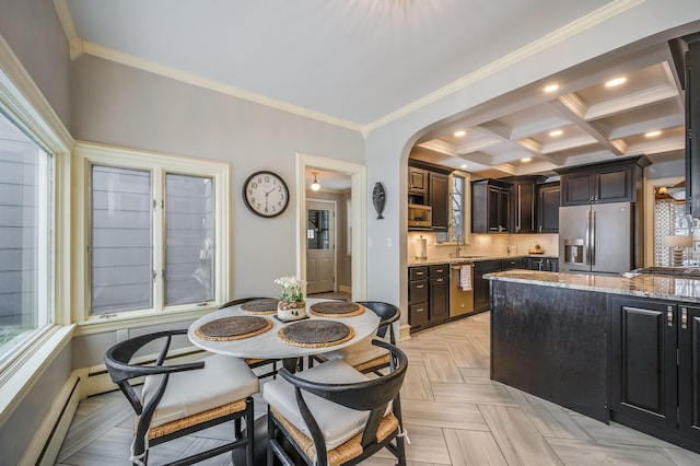 kitchen with light stone counters, a baseboard radiator, recessed lighting, arched walkways, and stainless steel appliances