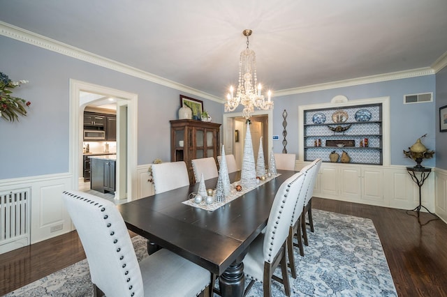 dining room featuring a wainscoted wall, dark wood-type flooring, visible vents, and ornamental molding