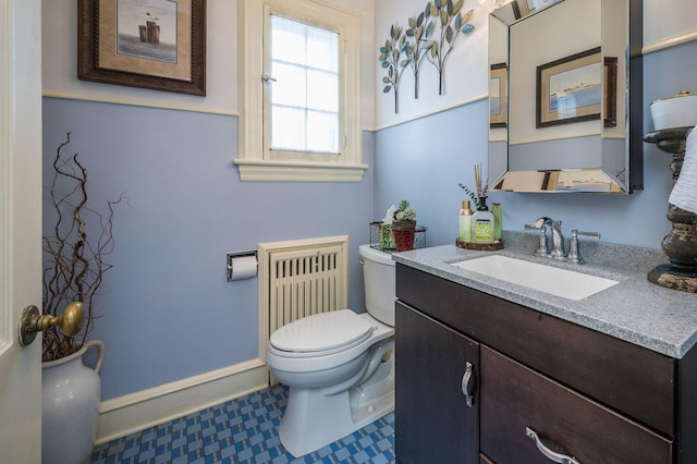 bathroom with radiator, toilet, and vanity