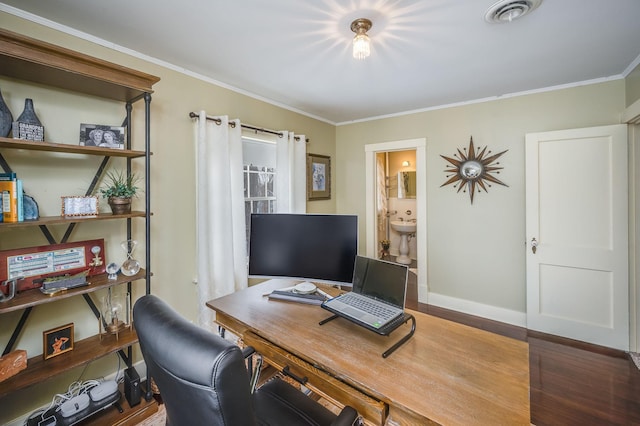 office space with crown molding, wood finished floors, visible vents, and baseboards