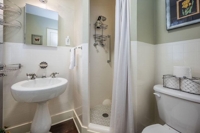 full bathroom featuring a shower stall, toilet, tile walls, and wainscoting