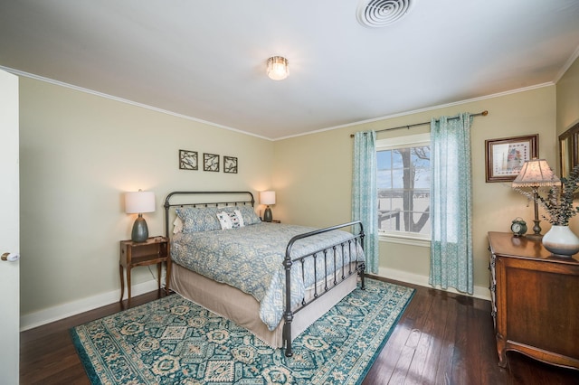 bedroom featuring visible vents, baseboards, wood finished floors, and ornamental molding