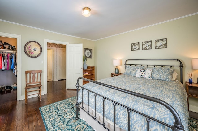 bedroom featuring a walk in closet, a closet, wood finished floors, and ornamental molding