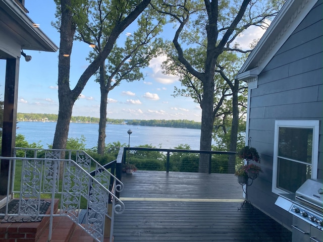 deck featuring a water view and a grill