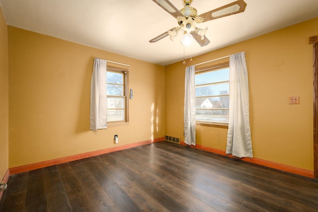 spare room featuring ceiling fan, plenty of natural light, and dark wood-type flooring