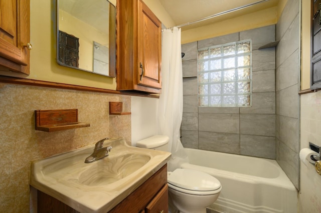 full bathroom with vanity, toilet, shower / bath combo with shower curtain, and tile walls