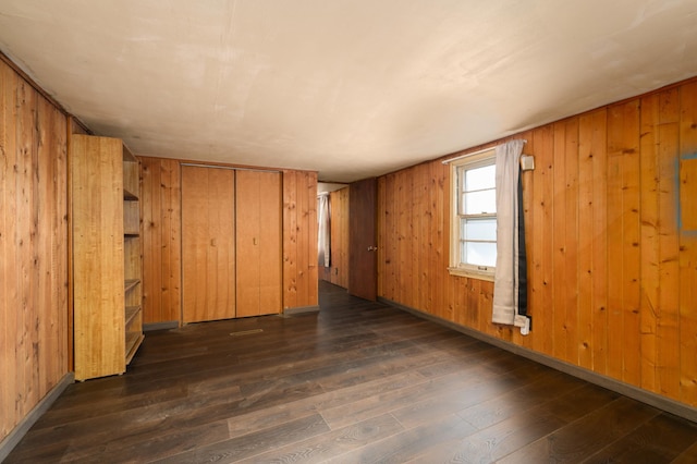 spare room with wooden walls and dark hardwood / wood-style flooring