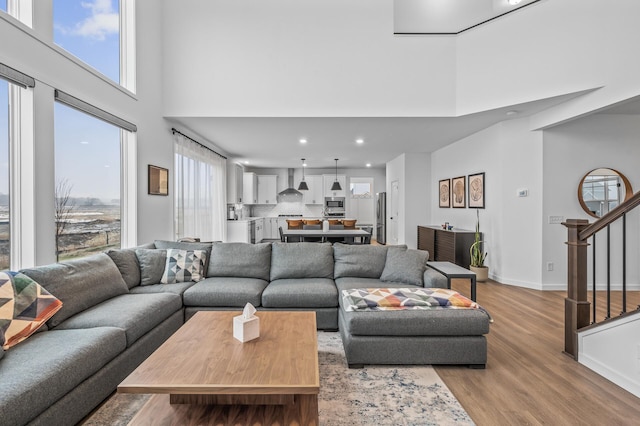 living room featuring a high ceiling and light wood-type flooring