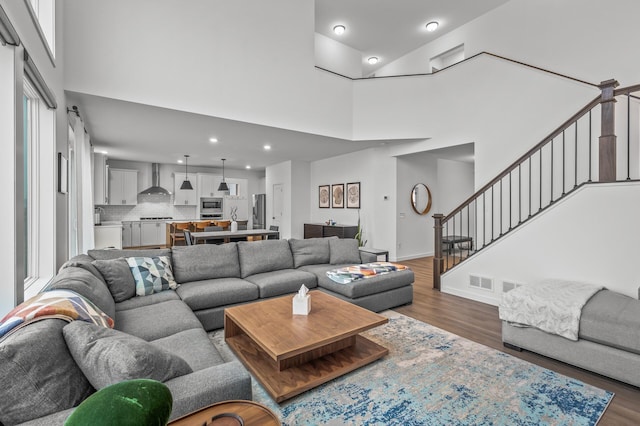 living room featuring dark hardwood / wood-style flooring and a towering ceiling