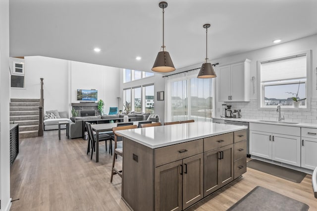 kitchen with pendant lighting, a center island, white cabinetry, and sink