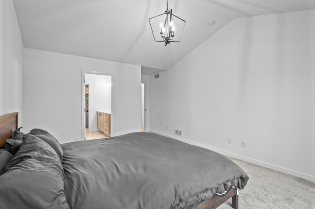 bedroom with ensuite bath, light carpet, a chandelier, and vaulted ceiling