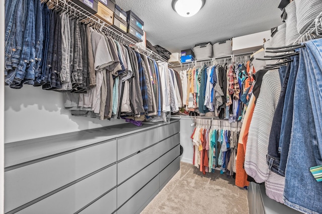 walk in closet featuring light colored carpet