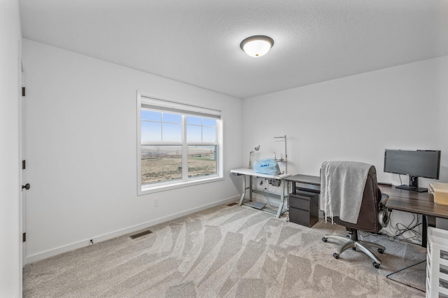 carpeted office featuring a textured ceiling