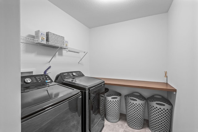 clothes washing area with washer and clothes dryer and a textured ceiling