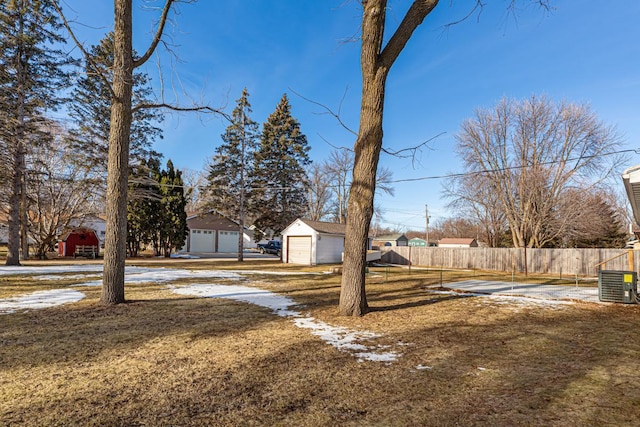 view of yard featuring an outbuilding, central AC, and a garage