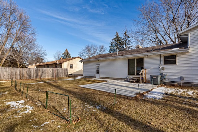 rear view of house with a lawn, cooling unit, and a patio