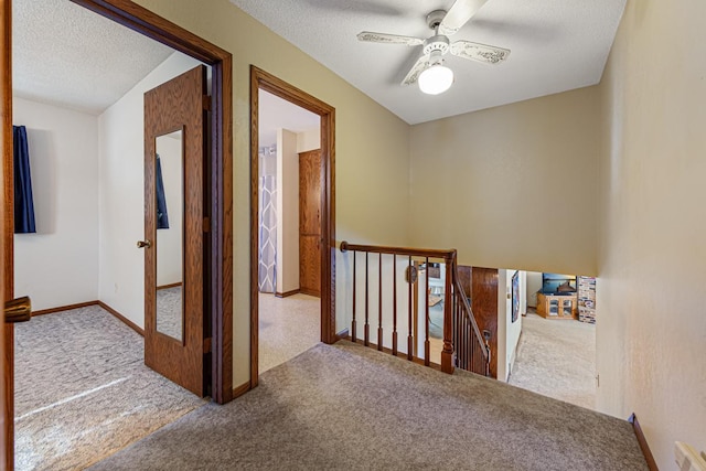 hall with carpet and a textured ceiling