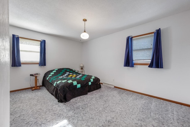 carpeted bedroom featuring a baseboard radiator and a textured ceiling