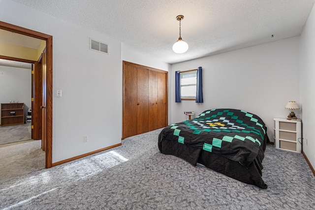 bedroom with carpet, a textured ceiling, and a closet