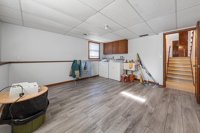 clothes washing area with cabinets, washing machine and dryer, and sink