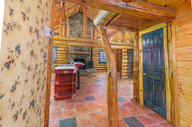 tiled foyer entrance with lofted ceiling with beams, wooden ceiling, and rustic walls