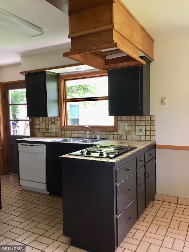 kitchen with black electric cooktop, decorative backsplash, sink, and white dishwasher