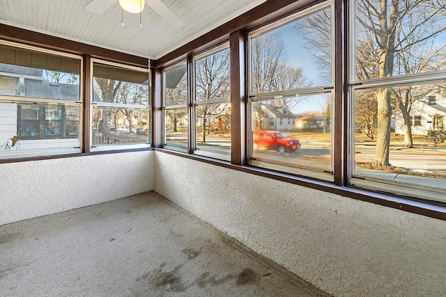 unfurnished sunroom featuring ceiling fan and plenty of natural light