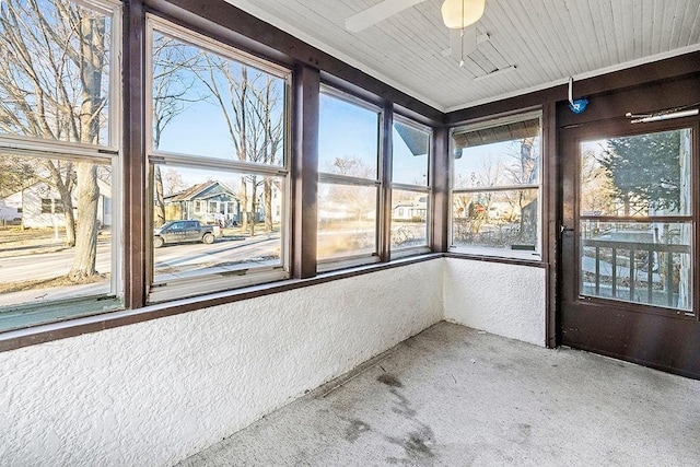 unfurnished sunroom with ceiling fan