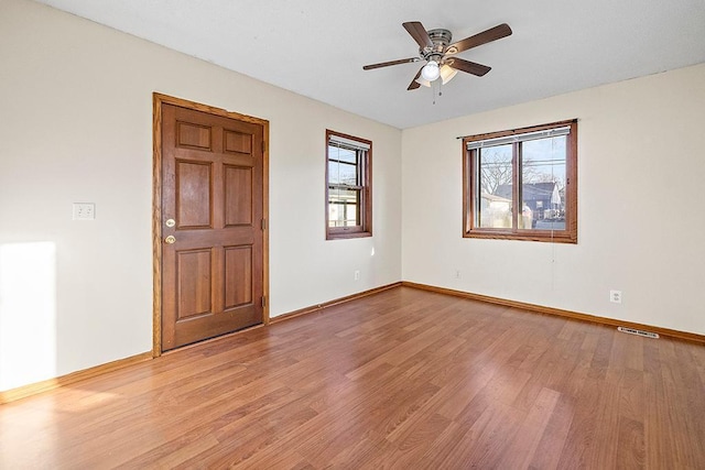 unfurnished room featuring ceiling fan, light hardwood / wood-style flooring, and a healthy amount of sunlight