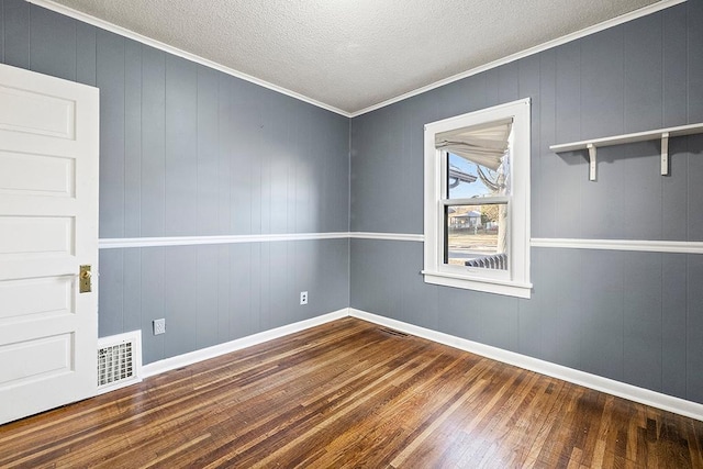 unfurnished room featuring wood-type flooring, a textured ceiling, and ornamental molding