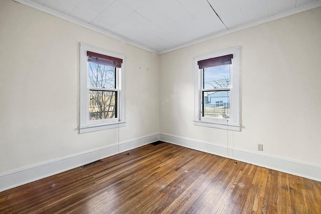 unfurnished room with plenty of natural light, wood-type flooring, and ornamental molding