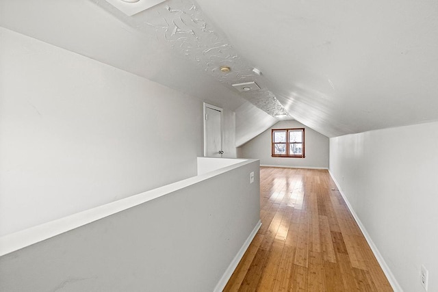 corridor featuring hardwood / wood-style floors and lofted ceiling