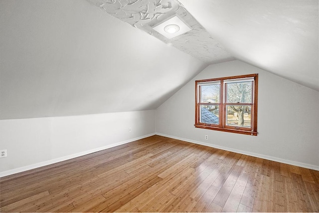 bonus room with hardwood / wood-style floors and lofted ceiling