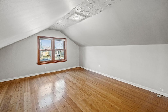 bonus room with light hardwood / wood-style flooring and vaulted ceiling