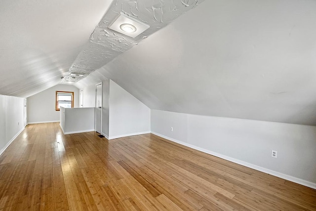 bonus room featuring lofted ceiling and light hardwood / wood-style flooring