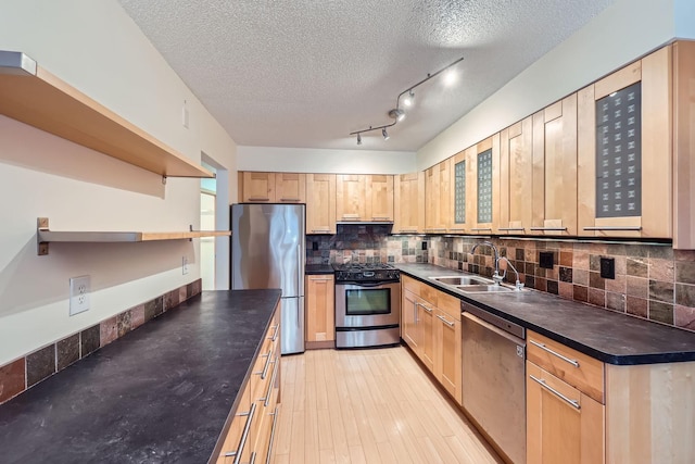 kitchen with light brown cabinets, sink, a textured ceiling, and appliances with stainless steel finishes