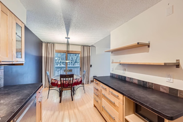 kitchen featuring dishwasher, light brown cabinetry, a textured ceiling, and light wood-type flooring