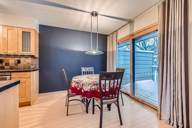 dining area featuring light hardwood / wood-style floors and a textured ceiling