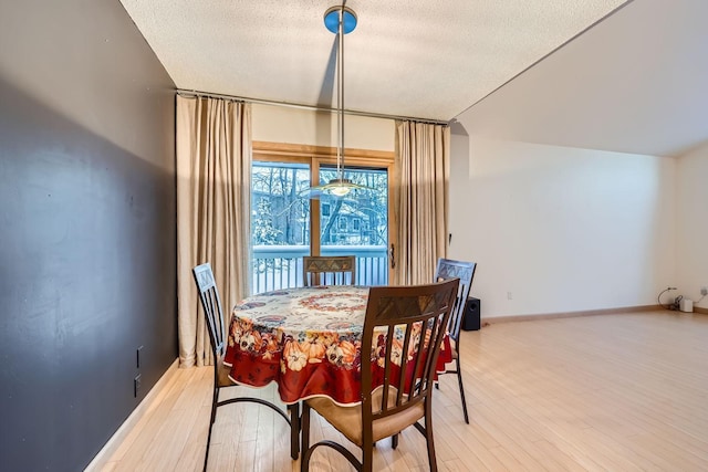 dining space featuring a textured ceiling and light hardwood / wood-style flooring