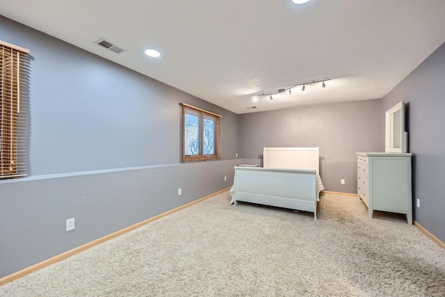 carpeted bedroom with track lighting