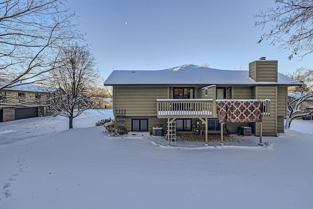 snow covered house featuring central air condition unit