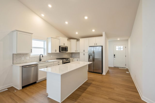 kitchen featuring a center island, sink, white cabinetry, and stainless steel appliances